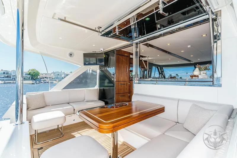 Slide: The Image of Luxurious 2026 Riviera 58 Sports Motor Yacht with elegant outdoor seating and wooden table. - 24