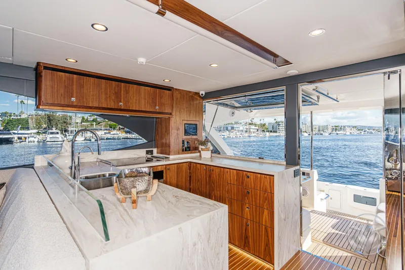 Slide: The Image of Luxurious interior of 2026 Riviera 58 Sports Motor Yacht with modern kitchen and scenic water view. - 30