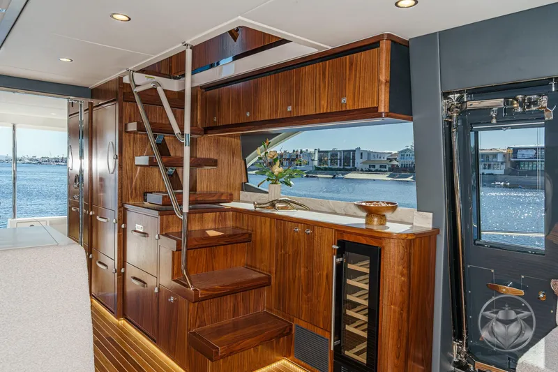 Slide: The Image of Luxurious interior of 2026 Riviera 58 Sports Motor Yacht with elegant wood finishes and waterfront view. - 33