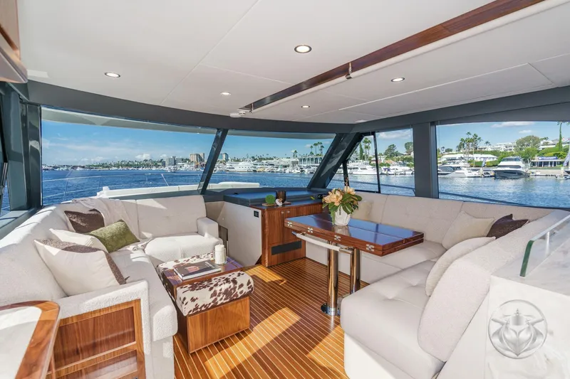 Slide: The Image of Luxurious interior of 2026 Riviera 58 Sports Motor Yacht with elegant seating and scenic marina views. - 36