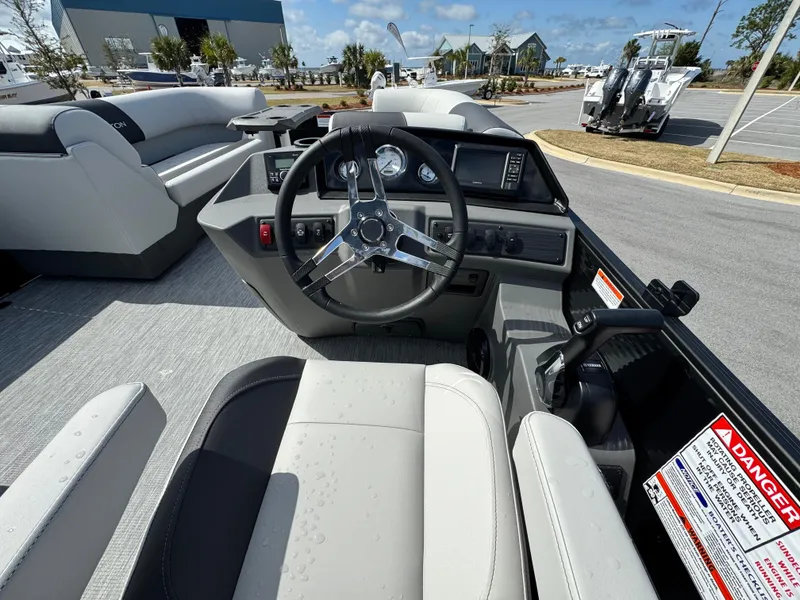 Slide: The Image of 2025 Bennington S Quad Bench 22 SSR boat interior with steering wheel and seating. - 12