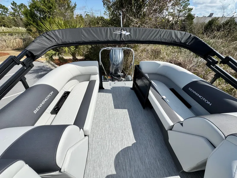 Slide: The Image of 2025 Bennington S Quad Bench 22 SSR pontoon boat interior with plush seating and canopy. - 7