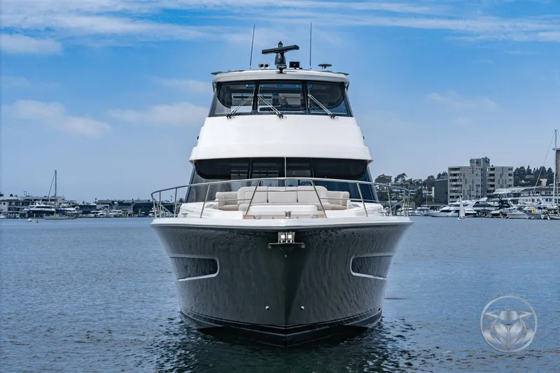 Slide: The Image of 2025 Riviera 64 Sports Motor Yacht on calm water, cityscape background. - 11