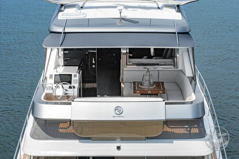 Slide: The Image of 2025 Riviera 64 Sports Motor Yacht, luxurious deck view with seating and helm. - 23