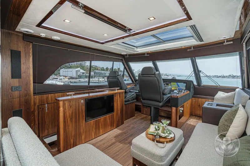 Slide: The Image of Luxurious interior of 2025 Riviera 64 Sports Motor Yacht with panoramic windows and elegant seating. - 29