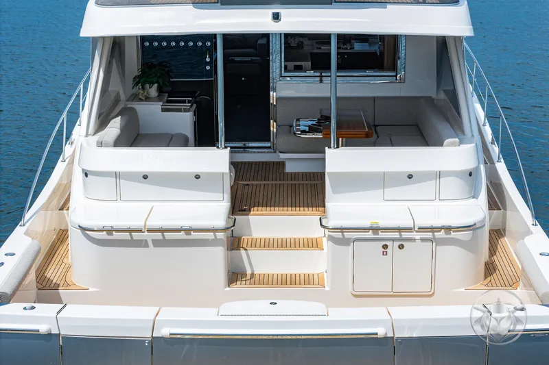 Slide: The Image of 2025 Riviera 64 Sports Motor Yacht, rear view, luxurious deck and seating area. - 33