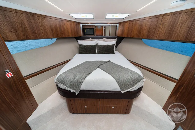 Slide: The Image of Luxurious bedroom interior of 2025 Riviera 64 Sports Motor Yacht with elegant wood finishes. - 48