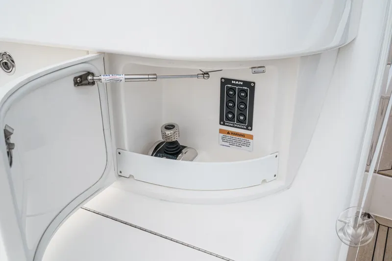Slide: The Image of Open compartment on 2025 Riviera 64 Sports Motor Yacht with control panel and gas strut. - 59