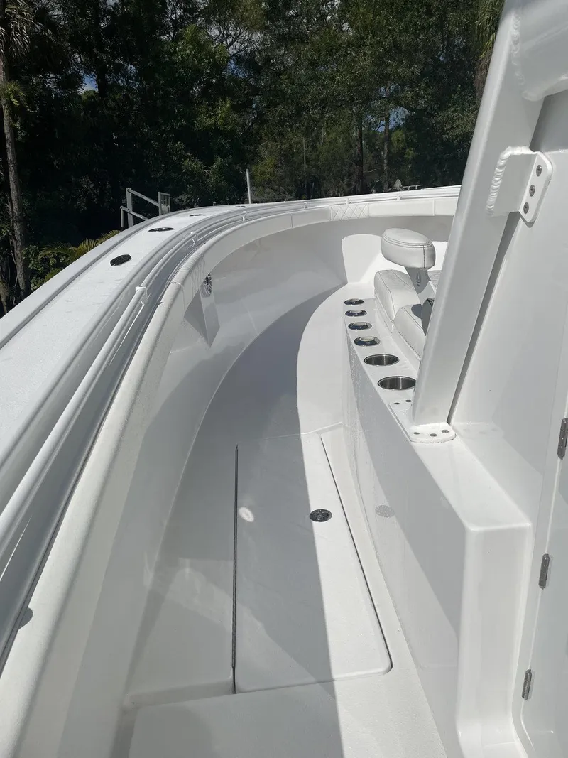 Slide: The Image of 2021 Onslow Bay 41 Tournament Edition boat interior with white seating on calm water. - 10