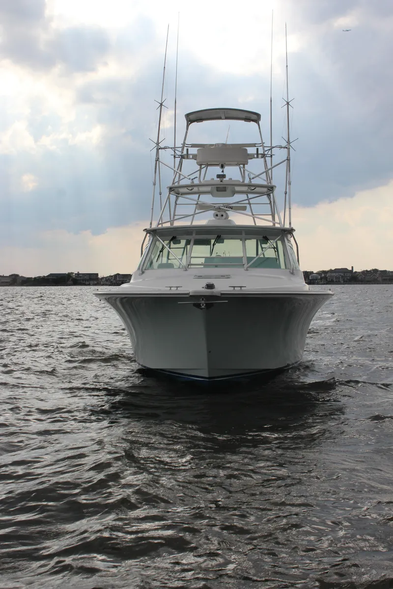 Slide: The Image of 2005 Cabo 40 Hardtop Express boat on water under cloudy sky. - 1
