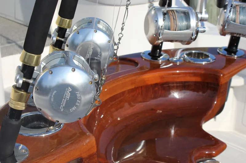 Slide: The Image of Fishing rods and reels on a polished wooden holder aboard a 2005 Cabo 40 Hardtop Express. - 10