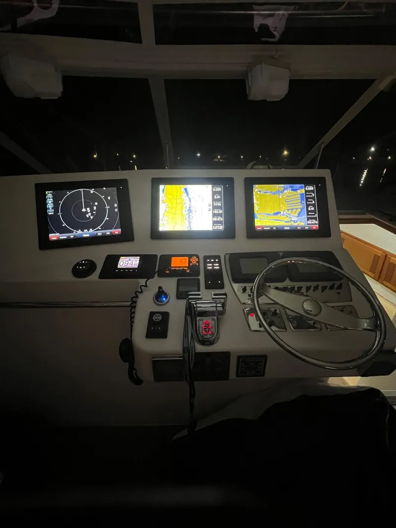 Slide: The Image of Control panel of a 2005 Cabo 40 Hardtop Express boat at night. - 14
