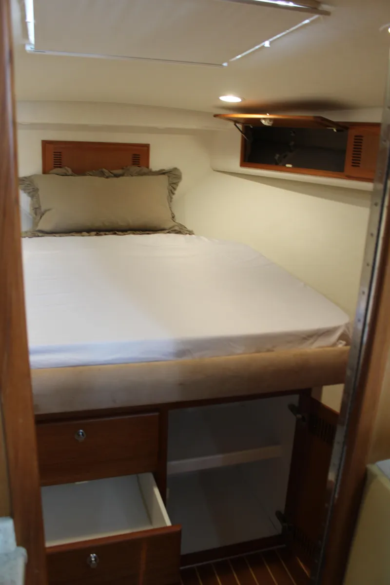 Slide: The Image of 2005 Cabo 40 Hardtop Express cabin with bed, storage drawers, and overhead compartment. - 21