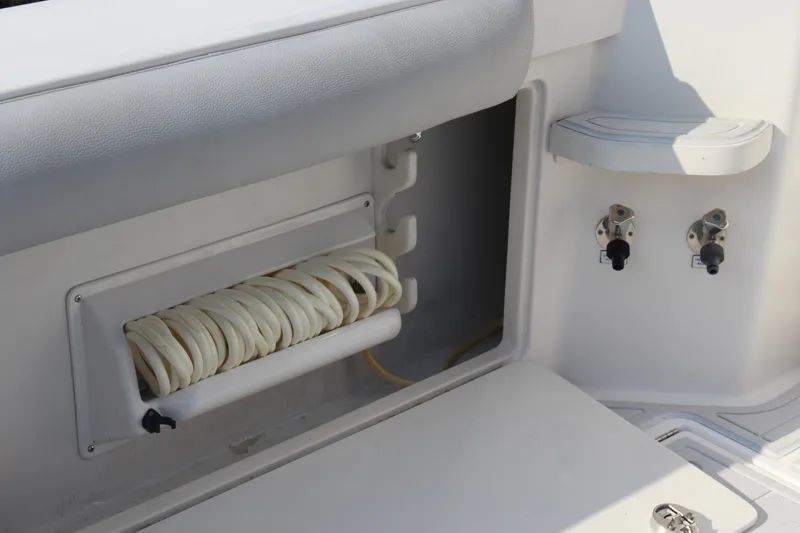 Slide: The Image of 2005 Cabo 40 Hardtop Express boat interior with hose storage and control valves. - 25