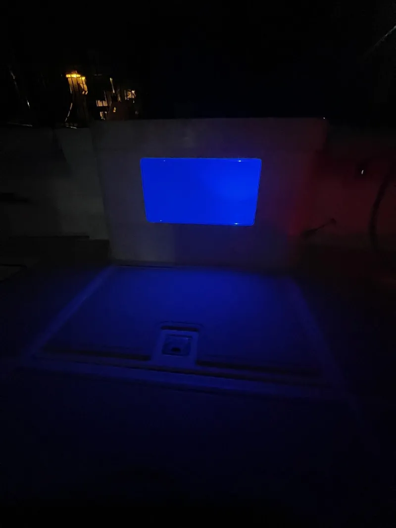 Slide: The Image of 2005 Cabo 40 Hardtop Express boat interior with blue ambient lighting at night. - 30