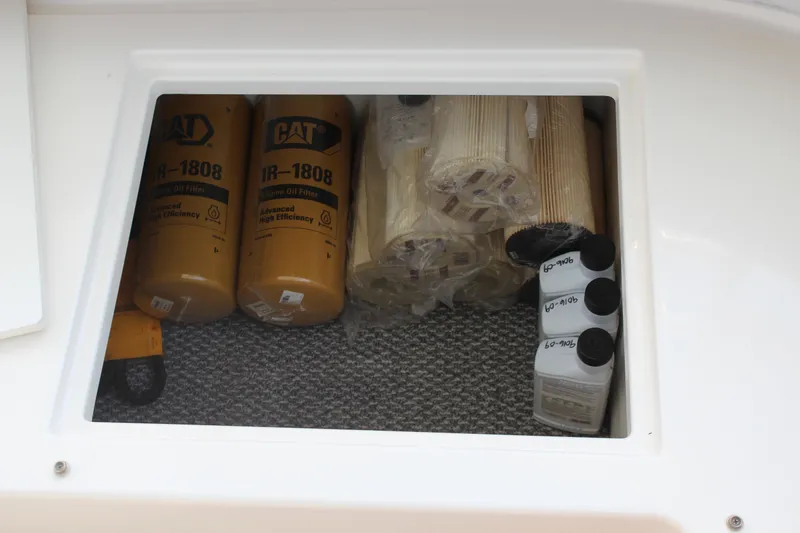 Slide: The Image of Storage compartment with CAT oil filters and bottles on a 2005 Cabo 40 Hardtop Express. - 32
