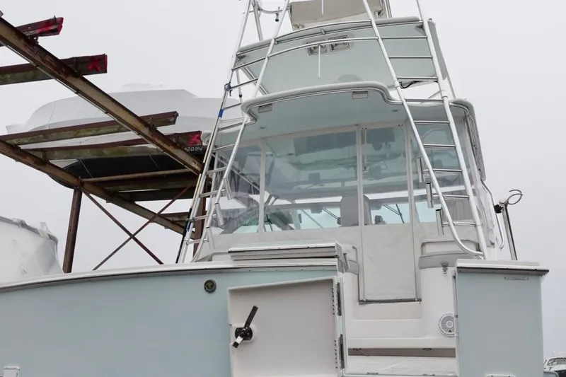 Slide: The Image of 2005 Cabo 40 Hardtop Express boat with tower, docked on a foggy day. - 36