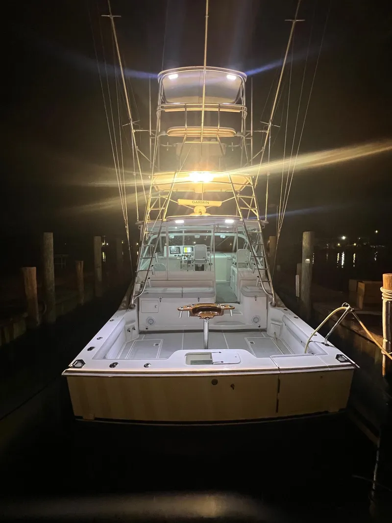 Slide: The Image of 2005 Cabo 40 Hardtop Express boat illuminated at night in a marina. - 4