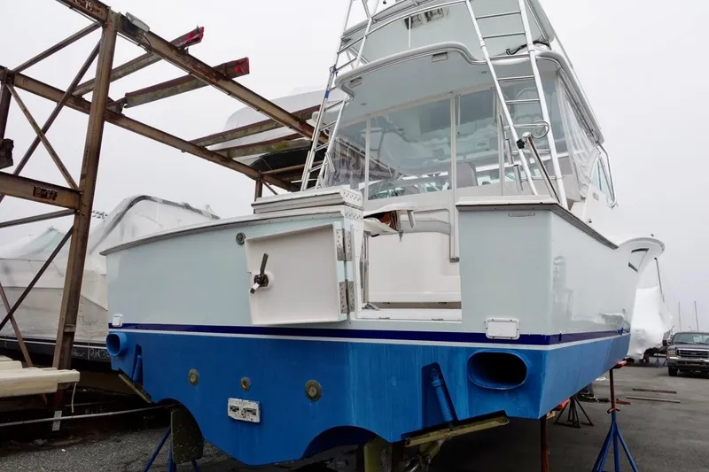 Slide: The Image of 2005 Cabo 40 Hardtop Express boat on stands, rear view, in a marina setting. - 6