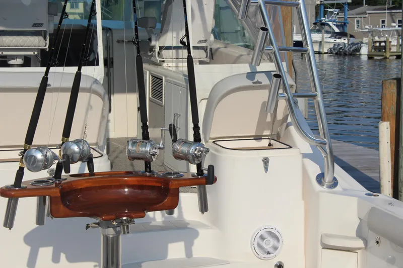 Slide: The Image of 2005 Cabo 40 Hardtop Express fishing boat with rods and ladder at dock. - 8