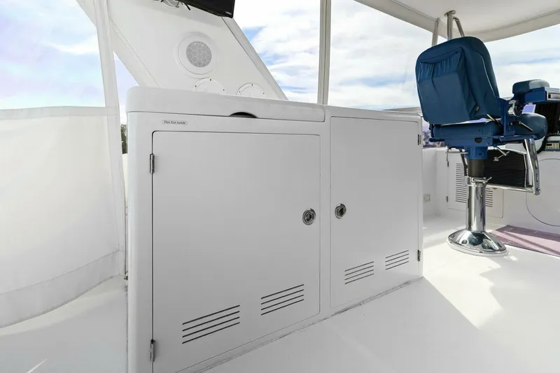 Slide: The Image of White boat interior with storage cabinets and a blue captain's chair. - 13