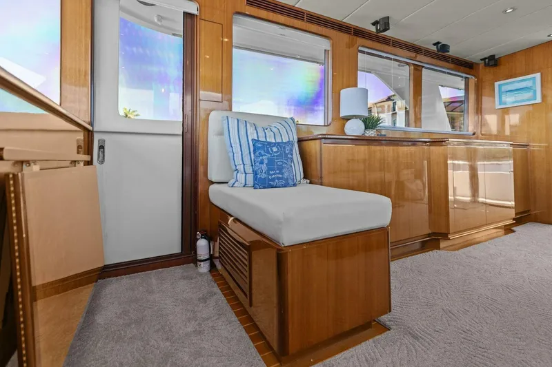Slide: The Image of Luxurious yacht interior with wooden paneling, cushioned seating, and decorative pillows. - 26