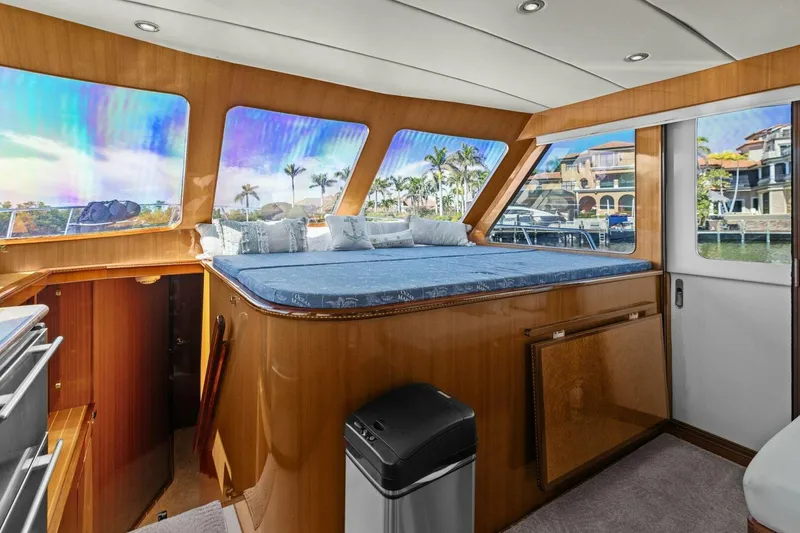 Slide: The Image of Luxurious yacht interior with panoramic windows and plush bedding, overlooking waterfront homes and palm trees. - 27