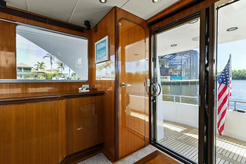 Slide: The Image of Luxurious yacht interior with wooden finish, glass door, and American flag on deck. - 35