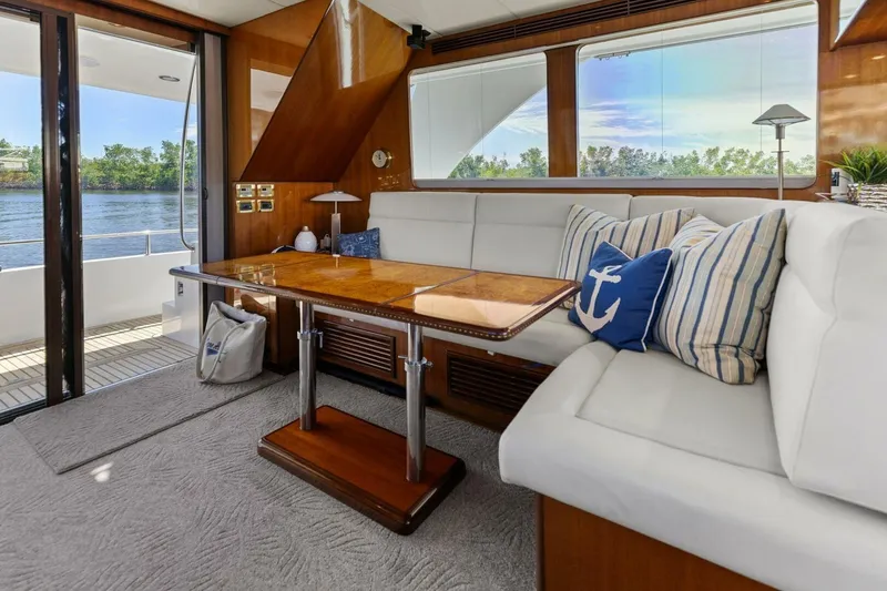 Slide: The Image of Luxurious yacht interior with white seating, wooden table, and nautical-themed pillows. - 4