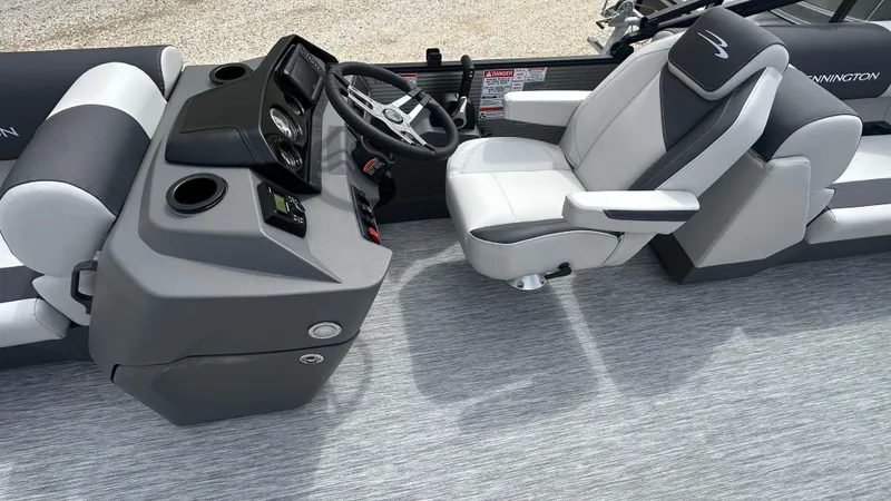 Slide: The Image of 2025 Bennington S Quad Bench 22 SSR boat interior with steering console and seating. - 11