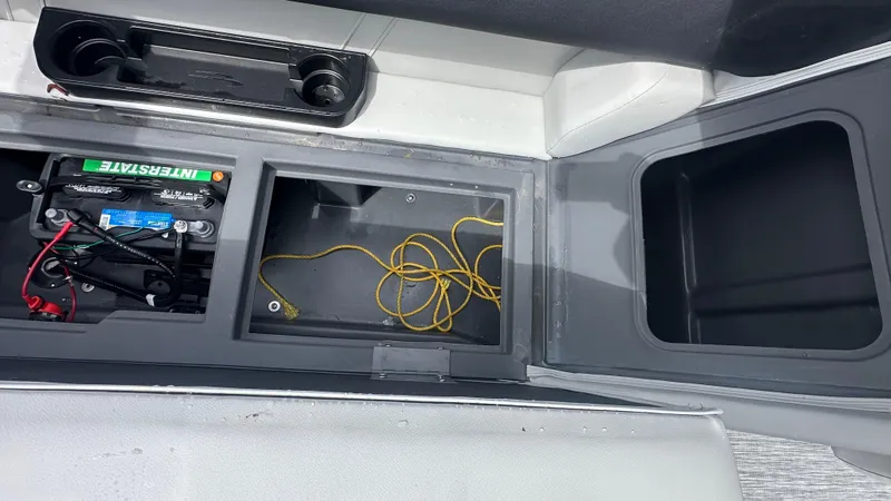 Slide: The Image of 2025 Bennington S Quad Bench 22 SSR storage compartments with battery and wiring. - 6