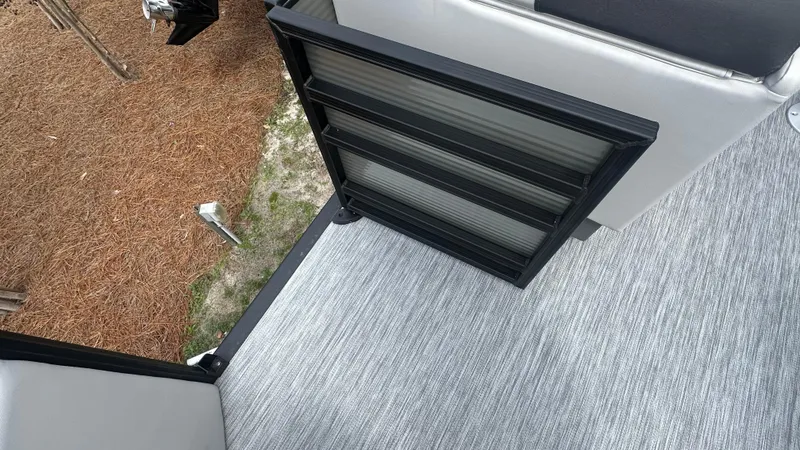 Slide: The Image of 2025 Bennington S Quad Bench 22 SSR boat interior with open gate and carpeted floor. - 8