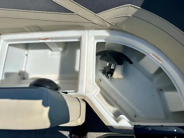 Slide: The Image of 2023 Barletta C20UC boat storage compartments with beige seating and visible equipment. - 17