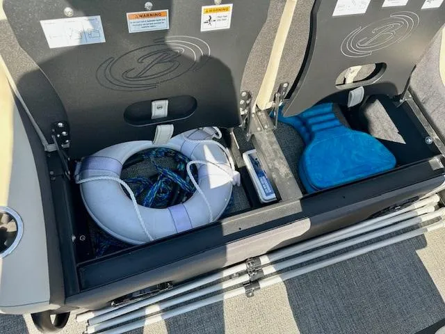 Slide: The Image of Storage compartments in a 2023 Barletta C20UC boat, featuring life jackets and safety equipment. - 18