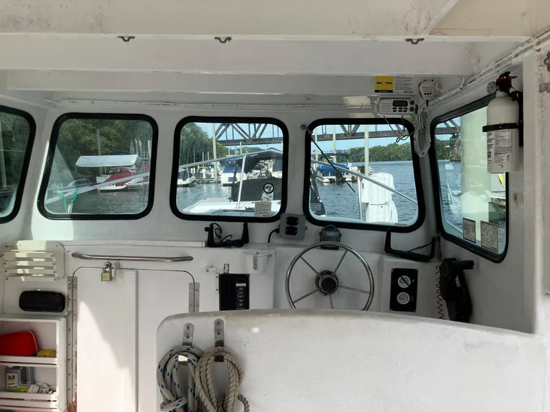 Slide: The Image of Interior view of a 2003 Cape Islander 22 boat with steering wheel and dockside windows. - 2