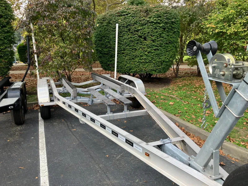 Slide: The Image of Boat trailer for Cape Islander 22, 2003 model, parked on asphalt near greenery. - 3