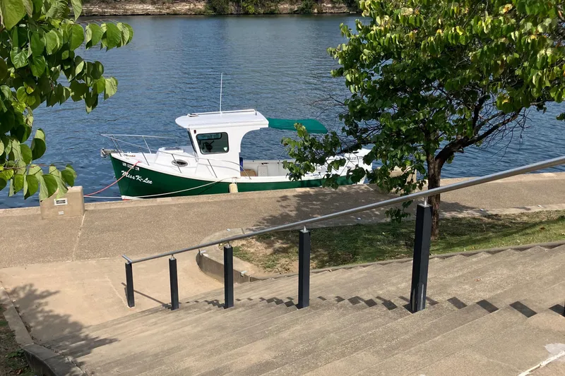 Slide: The Image of Cape Islander 22 boat docked by riverside, surrounded by trees and steps, 2003 model. - 5