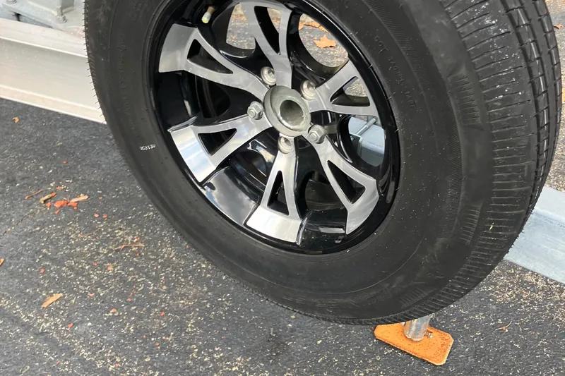 Slide: The Image of Close-up of a Cape Islander 22 trailer wheel, 2003 model, on asphalt. - 6