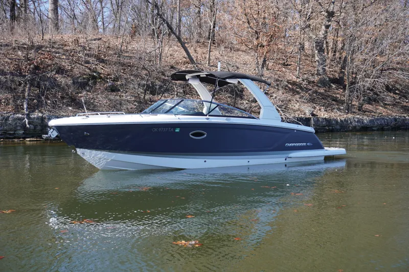 Slide: The Image of 2022 Chaparral 287 SSX boat on calm water, surrounded by bare trees. - 1