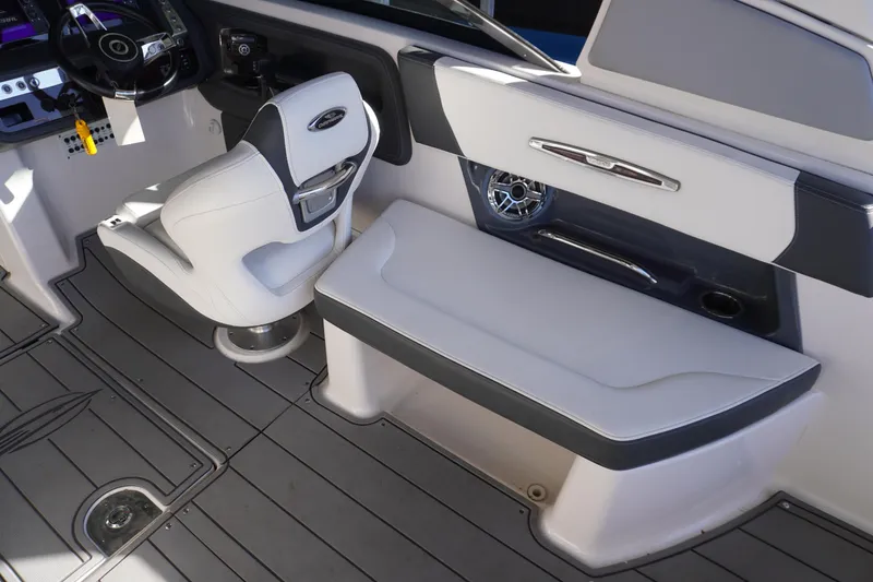 Slide: The Image of 2022 Chaparral 287 SSX boat interior with white seating and modern dashboard. - 11