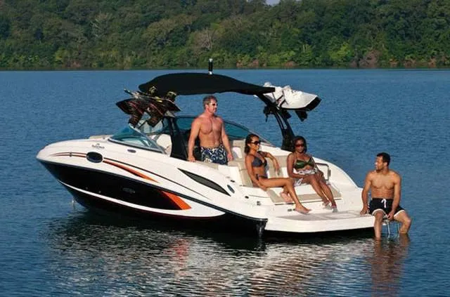Slide: The Image of 2012 Sea Ray 260 Sundeck with people relaxing on a lake. - 2