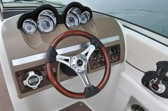 Slide: The Image of 2012 Sea Ray 260 Sundeck dashboard with wood-accented steering wheel and gauges. - 3