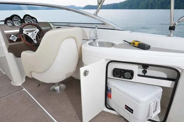 Slide: The Image of 2012 Sea Ray 260 Sundeck interior with helm, sink, and storage compartment. - 4