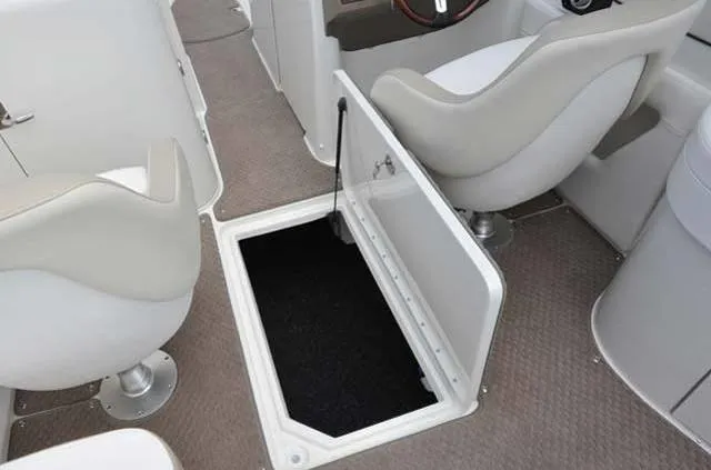 Slide: The Image of 2012 Sea Ray 260 Sundeck interior with open storage compartment and seating. - 5