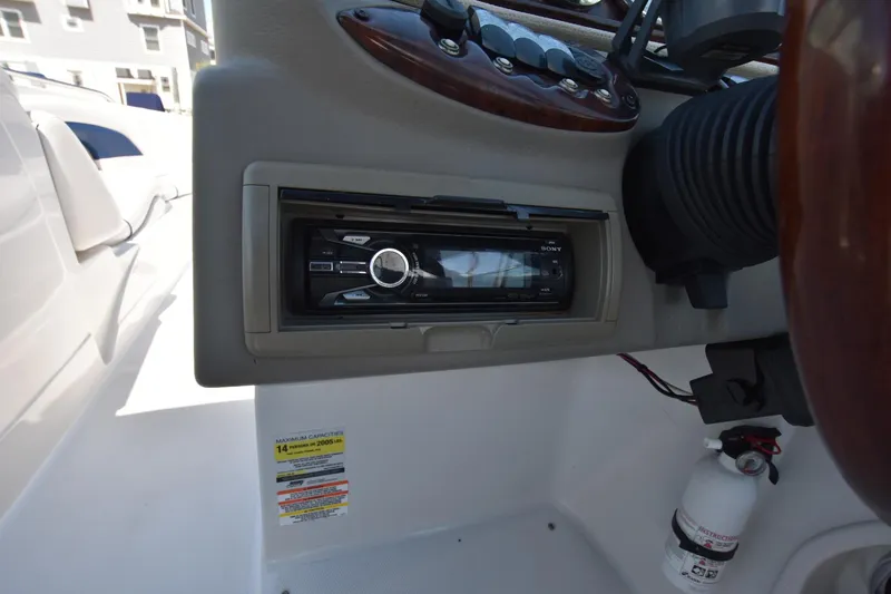 Slide: The Image of 2011 Crownline 265 SS boat dashboard with stereo system and fire extinguisher. - 17