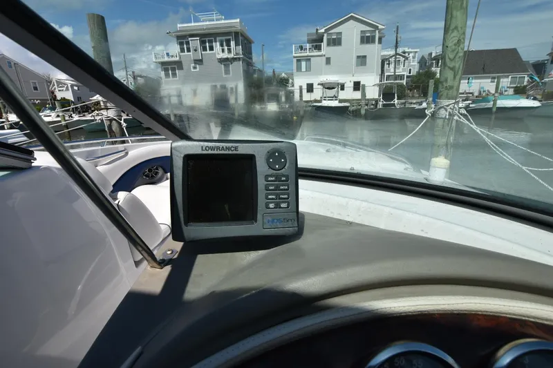 Slide: The Image of Crownline 265 SS boat dashboard with Lowrance GPS, docked near waterfront homes, 2011 model. - 18