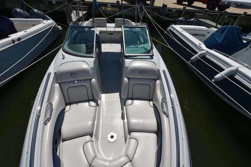 Slide: The Image of 2011 Crownline 265 SS boat with spacious seating, docked between other boats. - 6