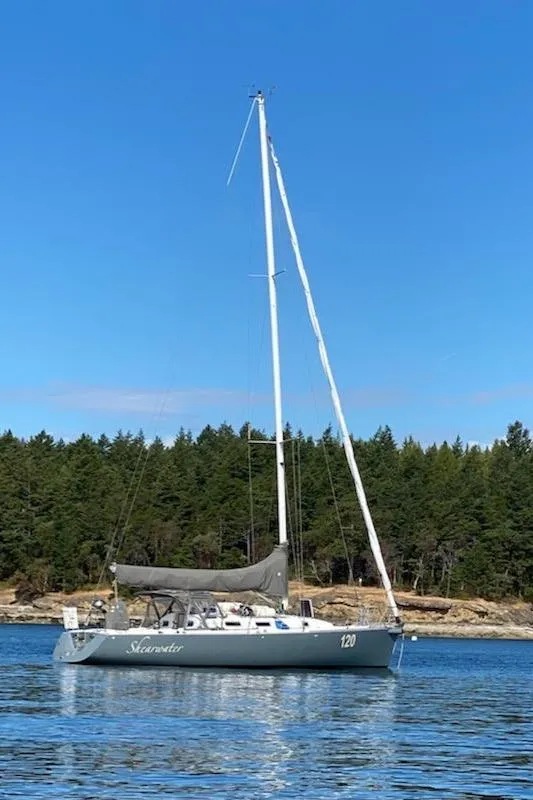 Slide: The Image of 1998 J Boats J/120 sailboat on calm water, forested shoreline in background. - 1