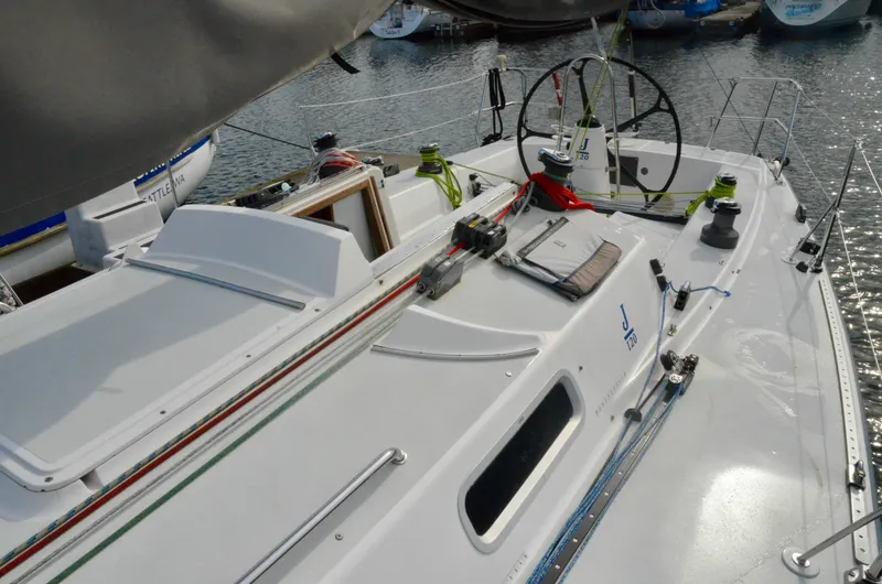 Slide: The Image of 1998 J Boats J/120 sailboat deck with steering wheel and rigging in marina. - 17