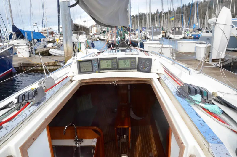 Slide: The Image of 1998 J Boats J/120 sailboat cockpit with navigation instruments, docked at a marina. - 24